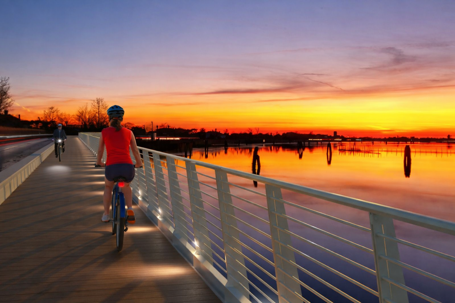 Ciclisti al tramonto lungo la passerella